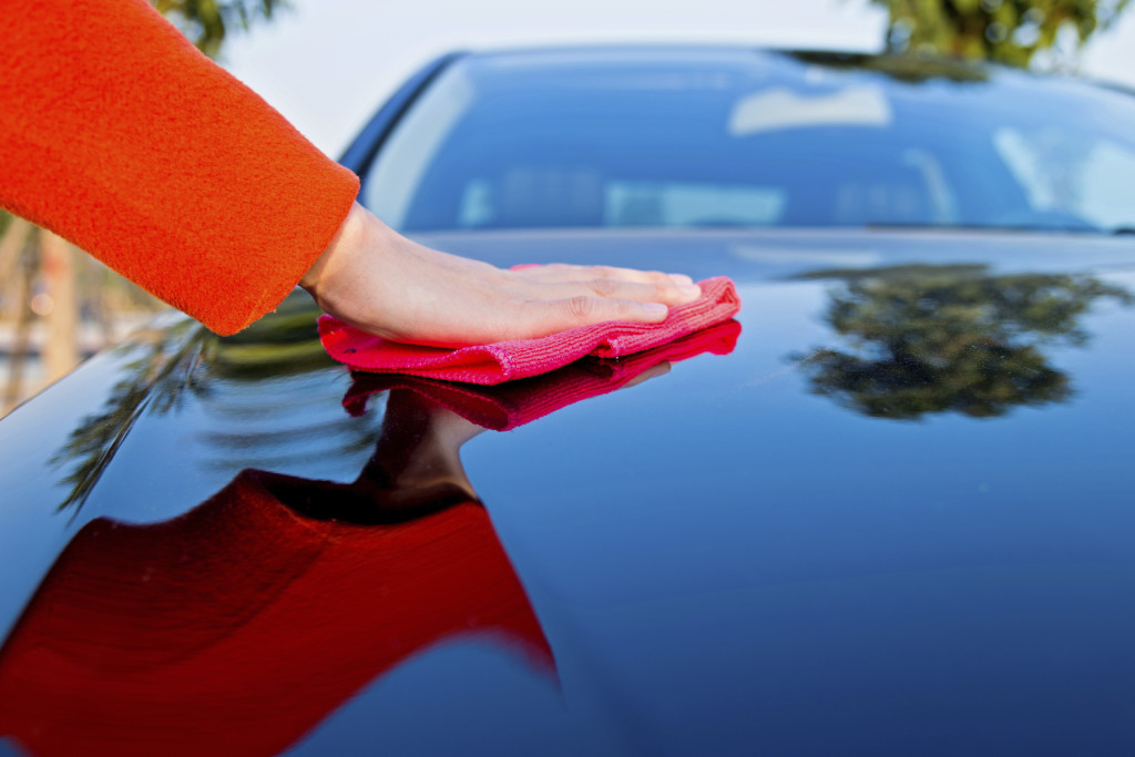 Woman hand polishing her car.